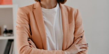close-up-portrait-smiling-short-haired-business-woman-white-t-shirt-posing-with-arms-crossed-white-office_197531-10725